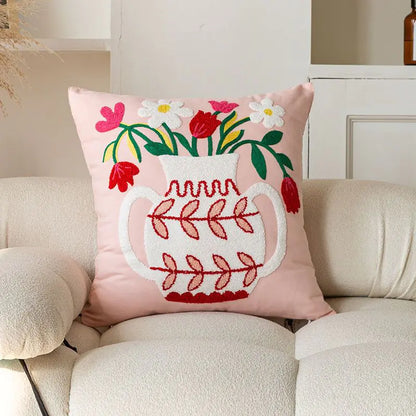 Living Abroad Creations pink floral embroidered pillow with flowers in a vase with soft lighting